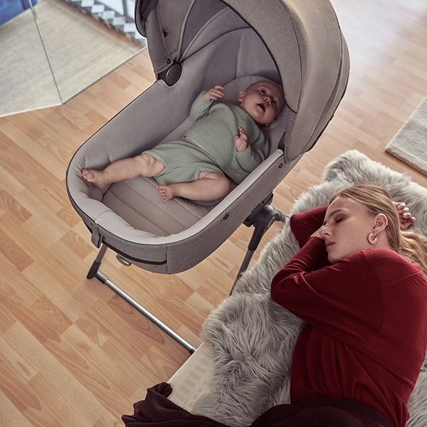 bebe descansando en el capazo del inglesina aptica con el soporte stand upo para uso como minicuna en casa